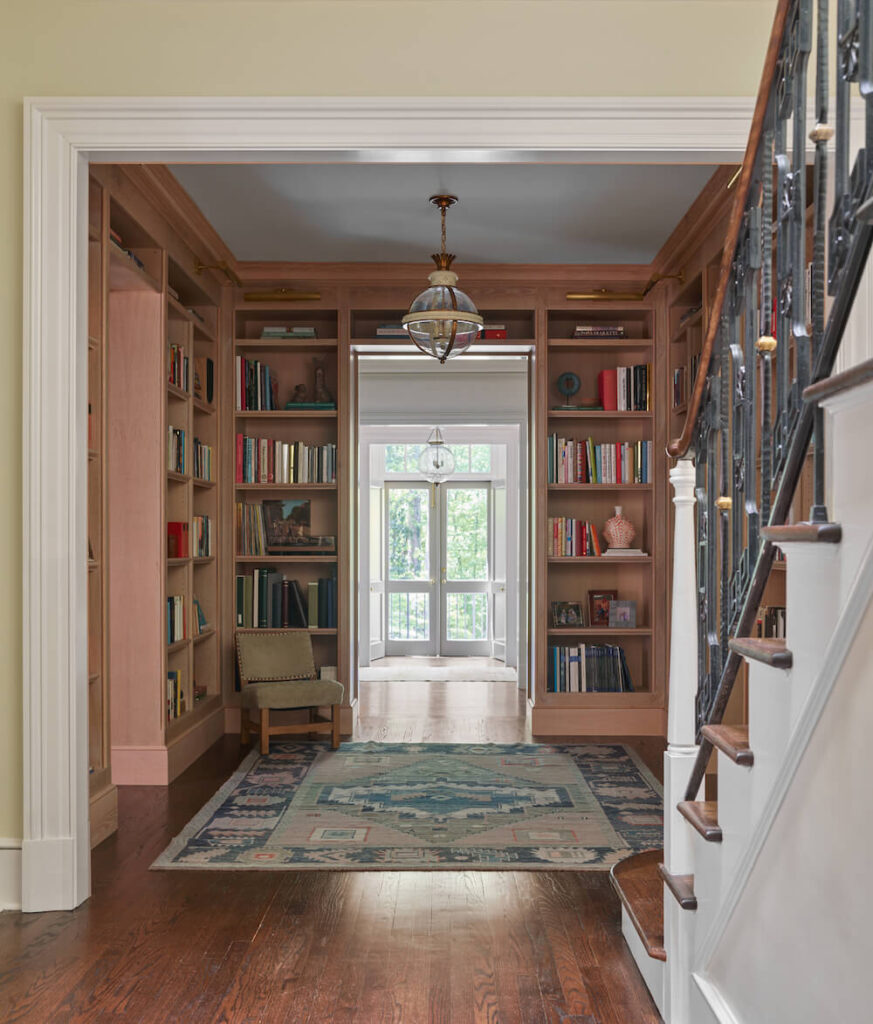A room with bookshelf walls with walkthrough through to double doors, T Blake Segars home design