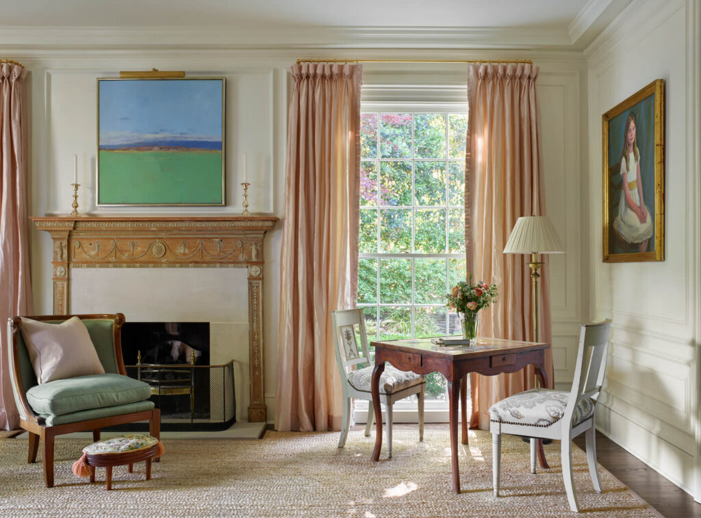 Classically designed room with writing desk, peach curtains and a fireplace