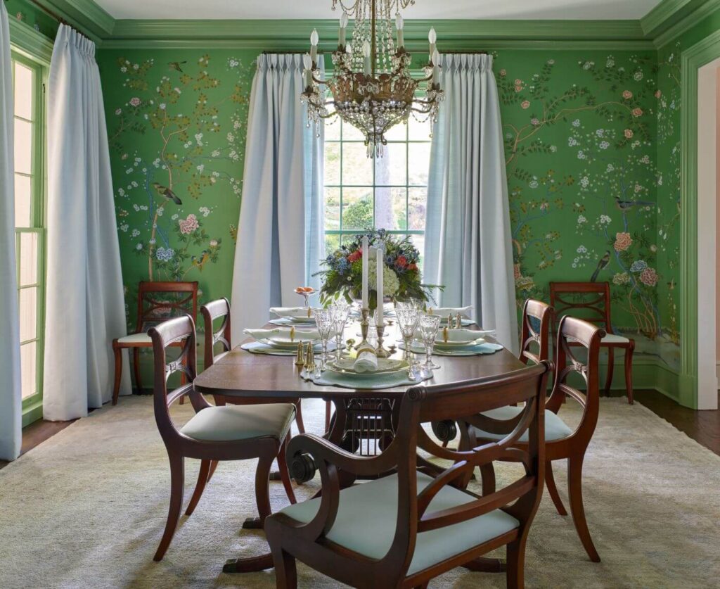 A dining table with chairs, and green decorative wall paper. Atlanta home architect T Blake Segars