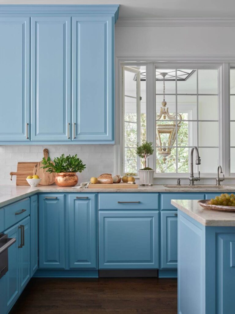 a kitchen with blue cabinets and wooden floors